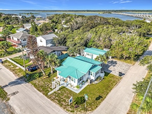 A residential area with houses, a paved road, and a body of water in the background. - Cottage & Bungalow | Coastal 2-Unit Retreat (St. Augustine)