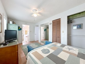 A bedroom with a bed, a television, a ceiling fan, and a wardrobe. - Cottage & Bungalow | Coastal 2-Unit Retreat (St. Augustine)