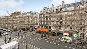 A street view with multi-story buildings, a pharmacy, and a crosswalk.