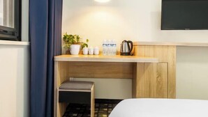 A hotel room with a bed, a small seating area, a kitchenette with a coffee maker, a TV, and a window with curtains. - Yun xiang Holiday Hotel (Zhengzhou Xinzheng International Airport) (Xinzheng)