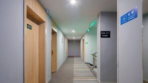A hotel hallway with wooden doors, a striped carpet, and directional signs for the elevator and room numbers 601 and 608-611. - Yun xiang Holiday Hotel (Zhengzhou Xinzheng International Airport) (Xinzheng)