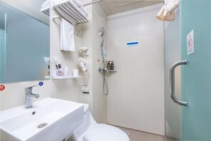 Un baño pequeño y limpio, con lavabo, inodoro y ducha.