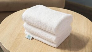 A stack of white towels on a wooden round table. - Yun xiang Holiday Hotel (Zhengzhou Xinzheng International Airport) (Xinzheng)