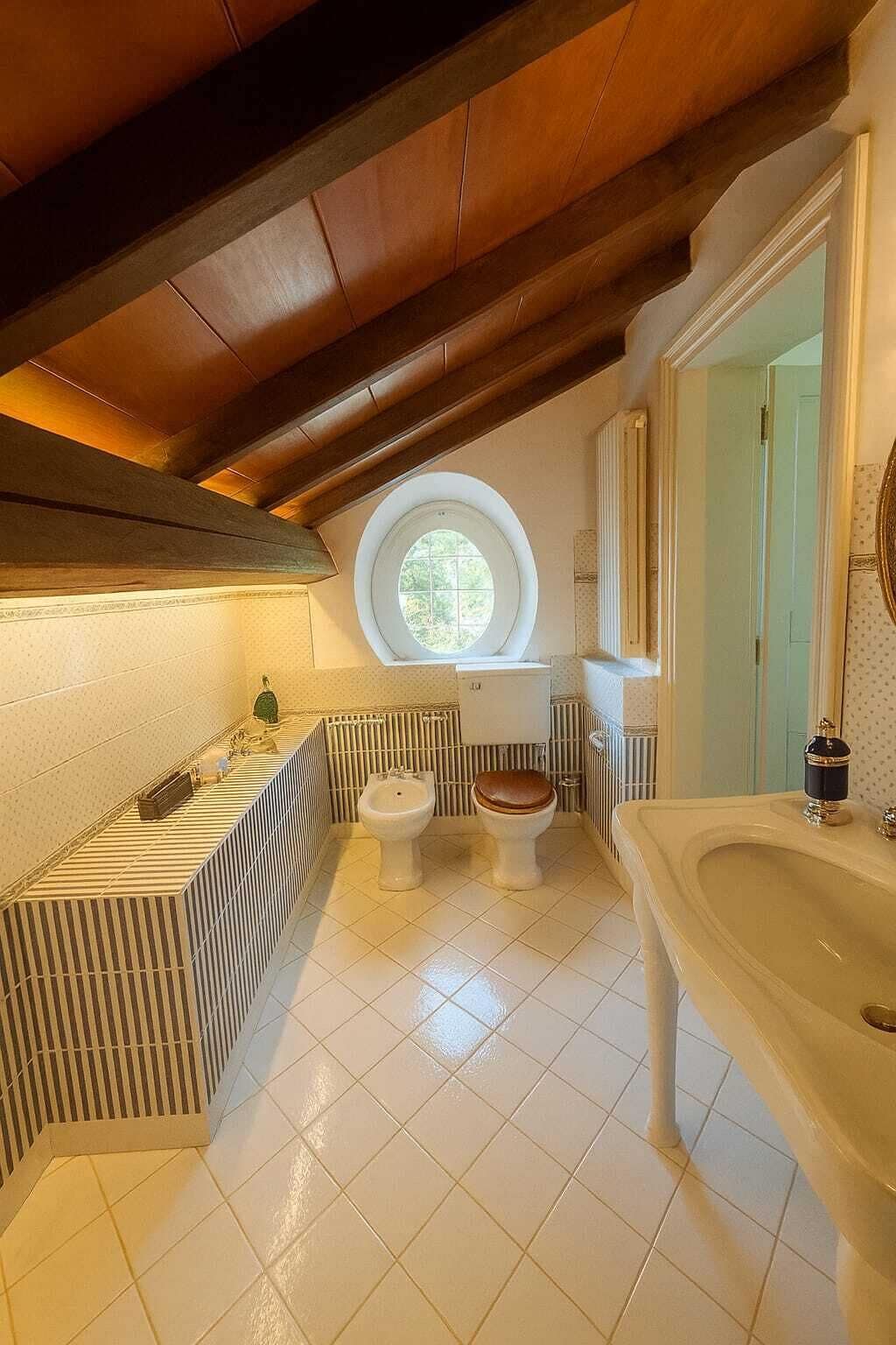 Ein Badezimmer mit Badewanne, Toilette, Bidet und einem großen Fenster.