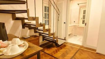Habitación cuádruple de lujo, vista al jardín | Área de sala de estar