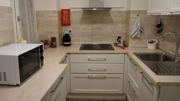 A modern kitchen with a microwave, stove, sink, and cabinets.