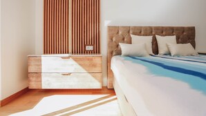 Een slaapkamer met een bed, een dressoir en een wand van houten latten.