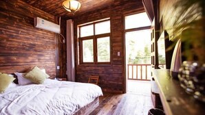 Een houten kamer met een bed, een raam en een deur naar buiten.
