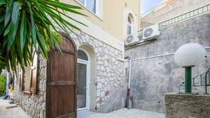 Un edificio in pietra con una porta di legno, un piccolo balcone e un lampione.