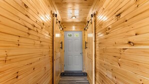 A wooden hallway with a door at the end, a welcome mat, and a small window. - Trailer Parking/Hot Tub/King Size Beds/Mt Views (Stanton)