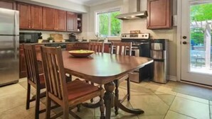 A spacious kitchen with a large island, wooden cabinets, and stainless steel appliances.