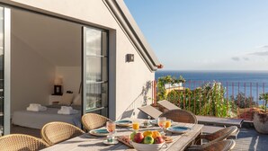 A balcony with a dining table set for breakfast, overlooking the ocean. - Eden Funchal by LovelyStay (Funchal)
