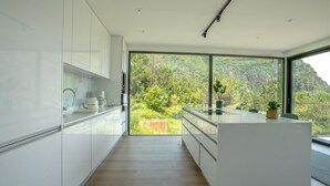 Eine moderne Küche mit Blick auf einen bewaldeten Berg.
