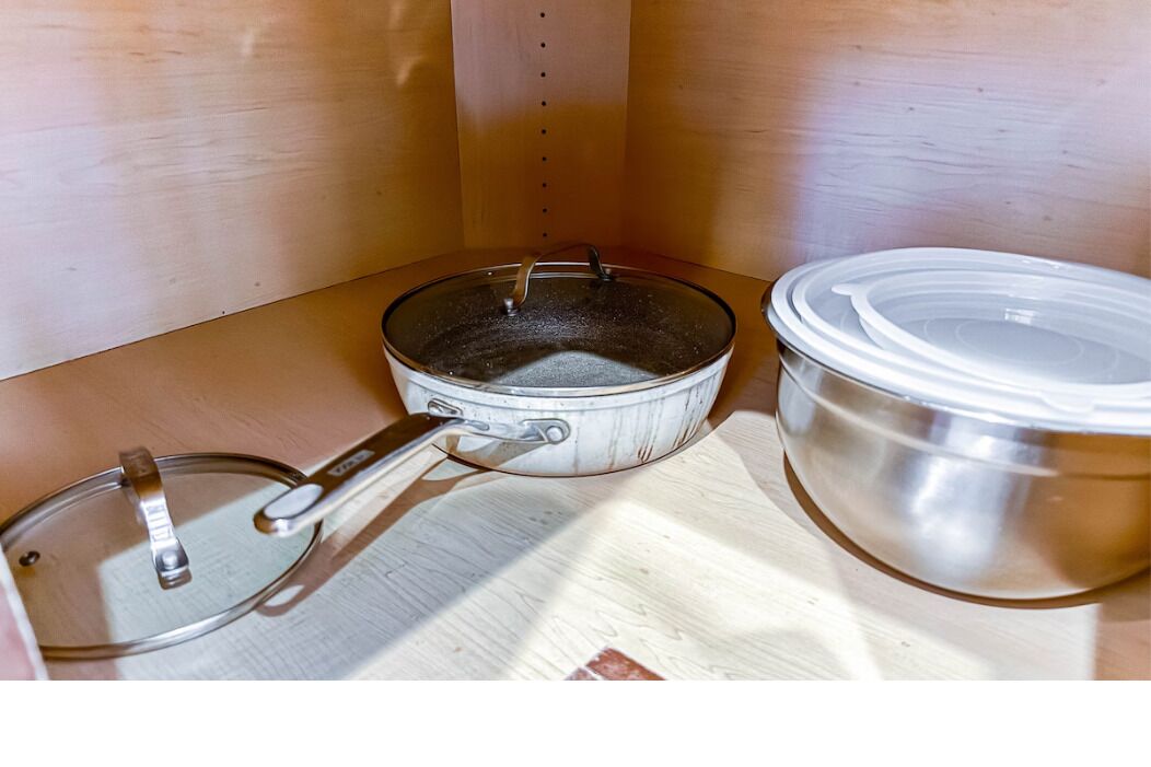 Une cuisine équipée d’une cuisinière, d’une poêle et d’une grande marmite.