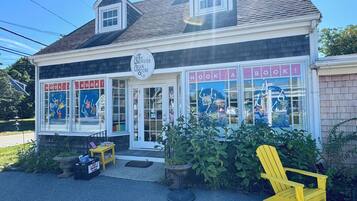 Un edificio con un letrero que dice "The Brewster Book Store" y "Hook a Book!", y una silla amarilla afuera.