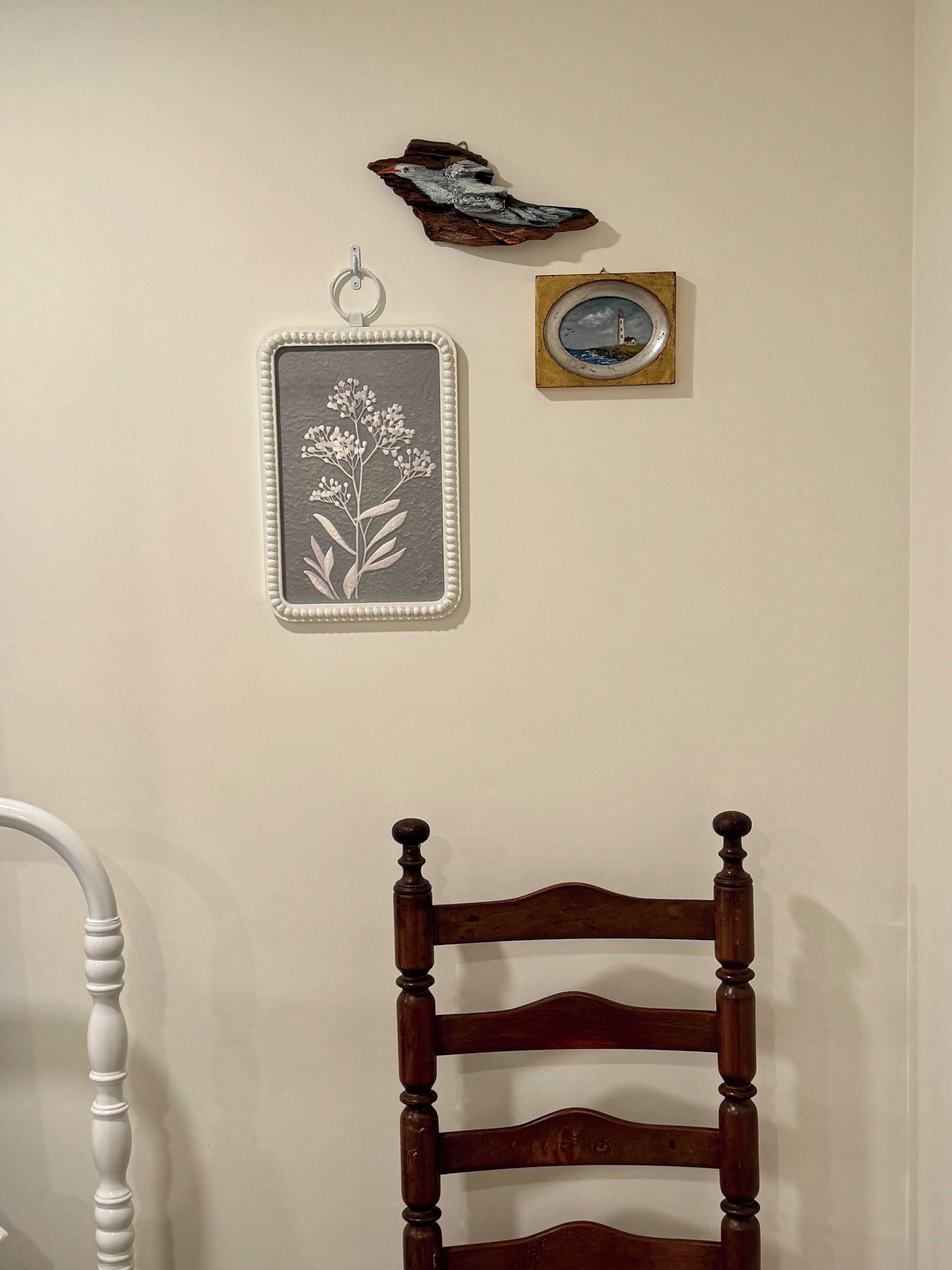 Een houten stoel met een gebogen rugleuning en gedraaide spijbels, geplaatst tegen een effen muur.
