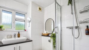 A modern bathroom with a shower, toilet, and sink.