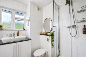 A modern bathroom with a shower, toilet, and sink.