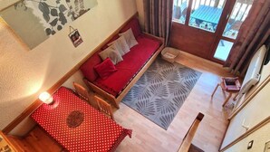 A cozy room with a sofa, a small table, and a staircase.