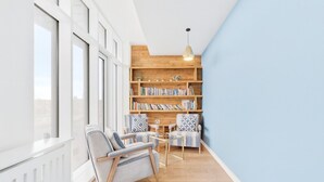 A modern living room with a wooden bookshelf, two armchairs, and a coffee table. - Luxury Penthouse in Harrow | 2BR | Gym | Games | Lounge | Free Parking (Harrow)