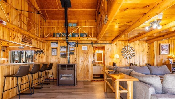 Un intérieur en bois avec un espace bar, des sièges et une cheminée.