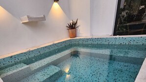 A swimming pool with a tiled floor and a small plant on the wall. - Azul Arena Hotel Boutique (Mazatlan)