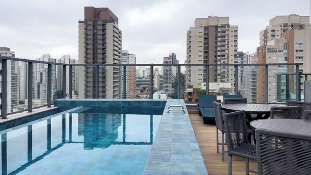 Un espace piscine aménagé sur le toit, offrant une vue sur les immeubles environnants.