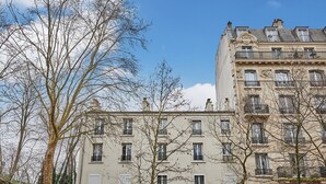 Un edificio de varios pisos con un estilo arquitectónico clásico, con balcones y ventanas amplias.