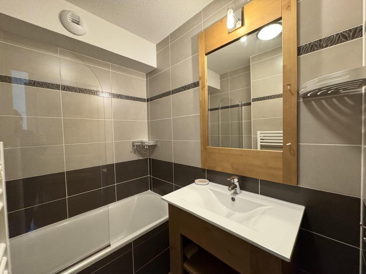 A bathroom with a bathtub, a sink, and a mirror.