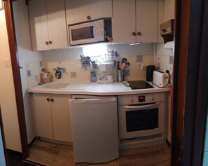 Eine kleine Küche mit Mikrowelle, Toaster und Backofen.