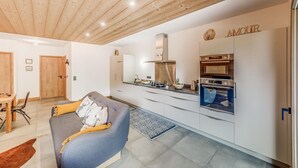 A modern kitchen with white cabinets, a built-in oven, and a countertop with various appliances.