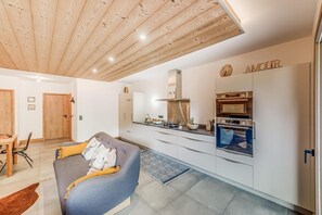 Eine moderne Küche mit weißen Schränken, einem eingebauten Backofen und einer Arbeitsplatte mit verschiedenen Geräten.
