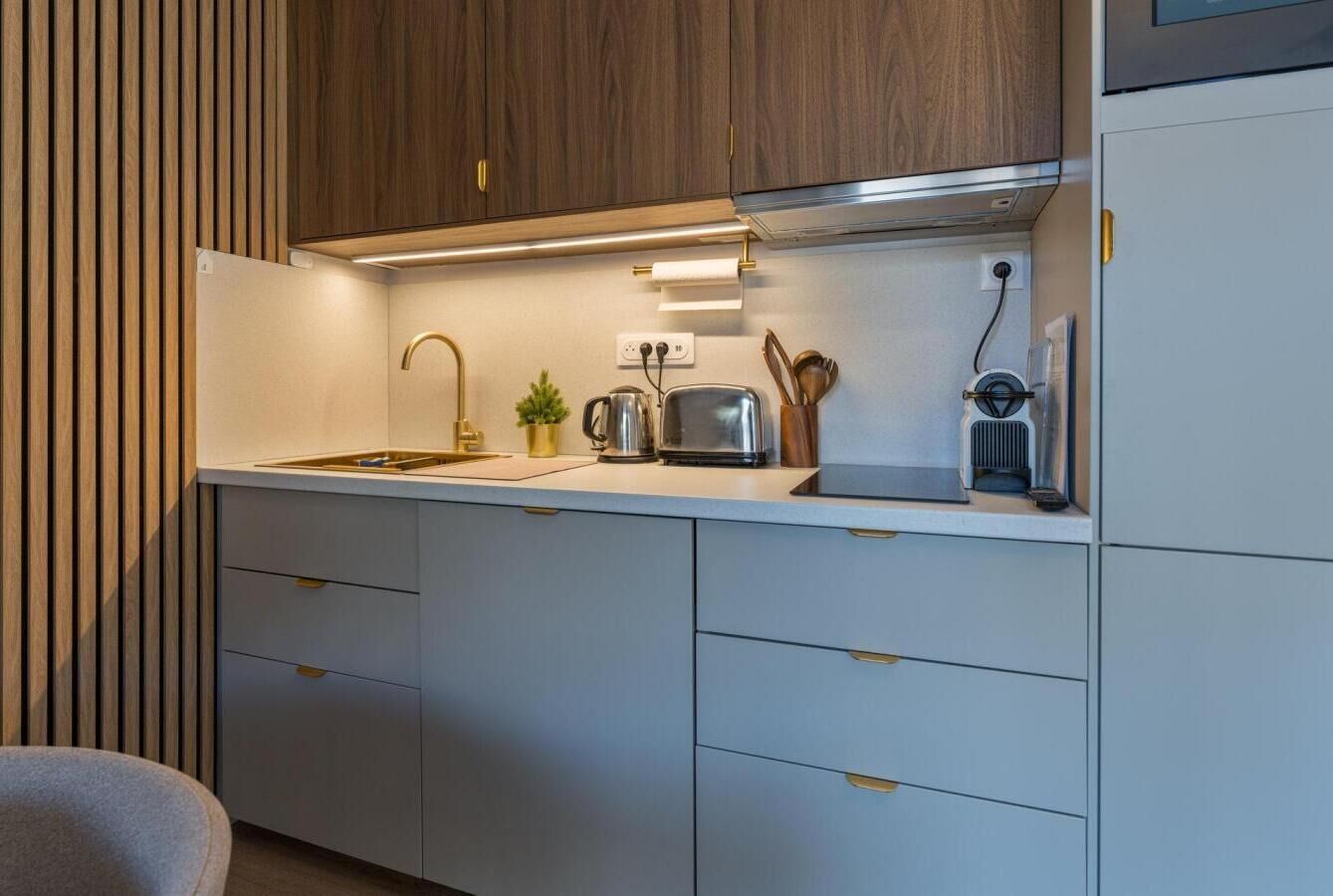 A modern kitchen with wooden cabinets, a stainless steel sink, and a built-in range hood.