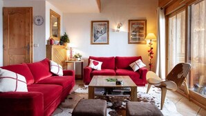 Ein gemütliches Wohnzimmer mit roten Sofas, einem Holztisch und einem Cowhide-Teppich.