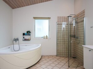 A bathroom with a bathtub, a shower, and a window. - 4 Star Holiday Home in Tarm (Tarm)