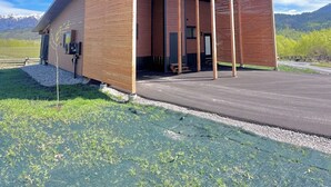A modern building with a sloped roof, large windows, and a covered entrance area. - Adventure Basecamp Fly Fishing Modern Alpine Home Near Jackson “Superfly” Cabin (Alpine)