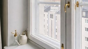 A window with a view of buildings and a white ledge with a kettle and a bottle. - Modern Top-Floor Apt. in Helsinki (Helsinki)