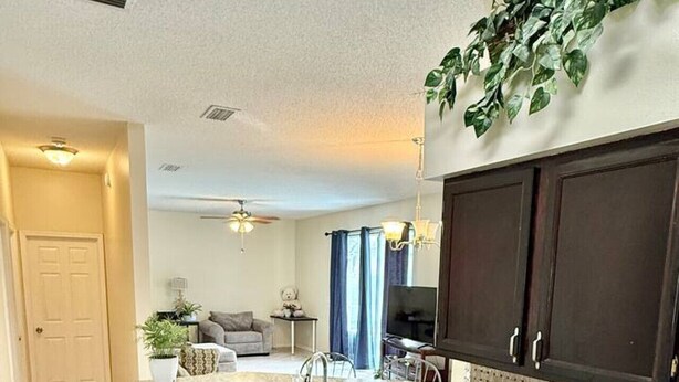 A kitchen with dark wood cabinets, granite countertops, and a built-in sink. - Spacious House w/ Heated Pool & Hot Tub near Tampa (Brandon)