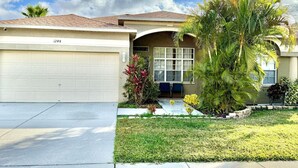 A single-story house with a garage, a front porch, and a well-maintained lawn. - Spacious House w/ Heated Pool & Hot Tub near Tampa (Brandon)
