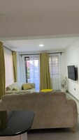 A living room with a beige sofa, a yellow side table, and a black coffee table.