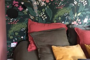 A bed with multiple pillows and a floral-patterned wall. - Charming cottage Sauna Garden Private parking (bidache)