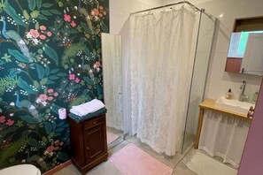 A bathroom with a shower curtain, a sink, and a vanity with a towel. - Charming cottage Sauna Garden Private parking (bidache)
