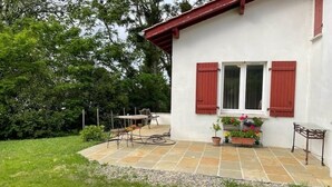 Et hus med terrasse, et bord og stole.