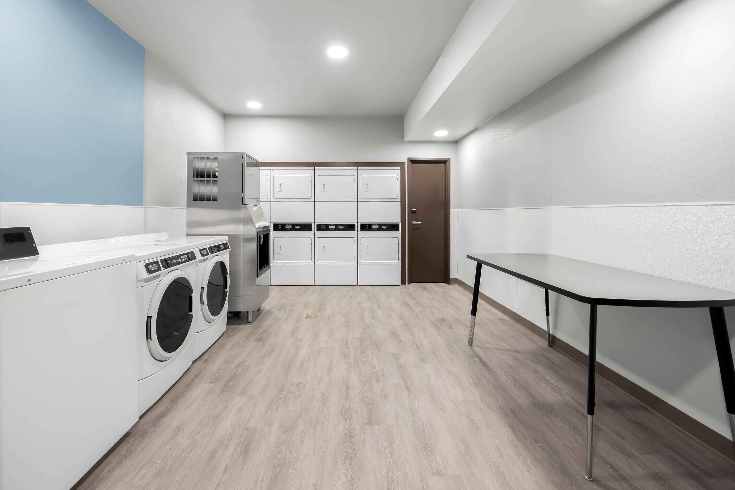 Une buanderie équipée d’un lave-linge, d’un sèche-linge et d’une table.