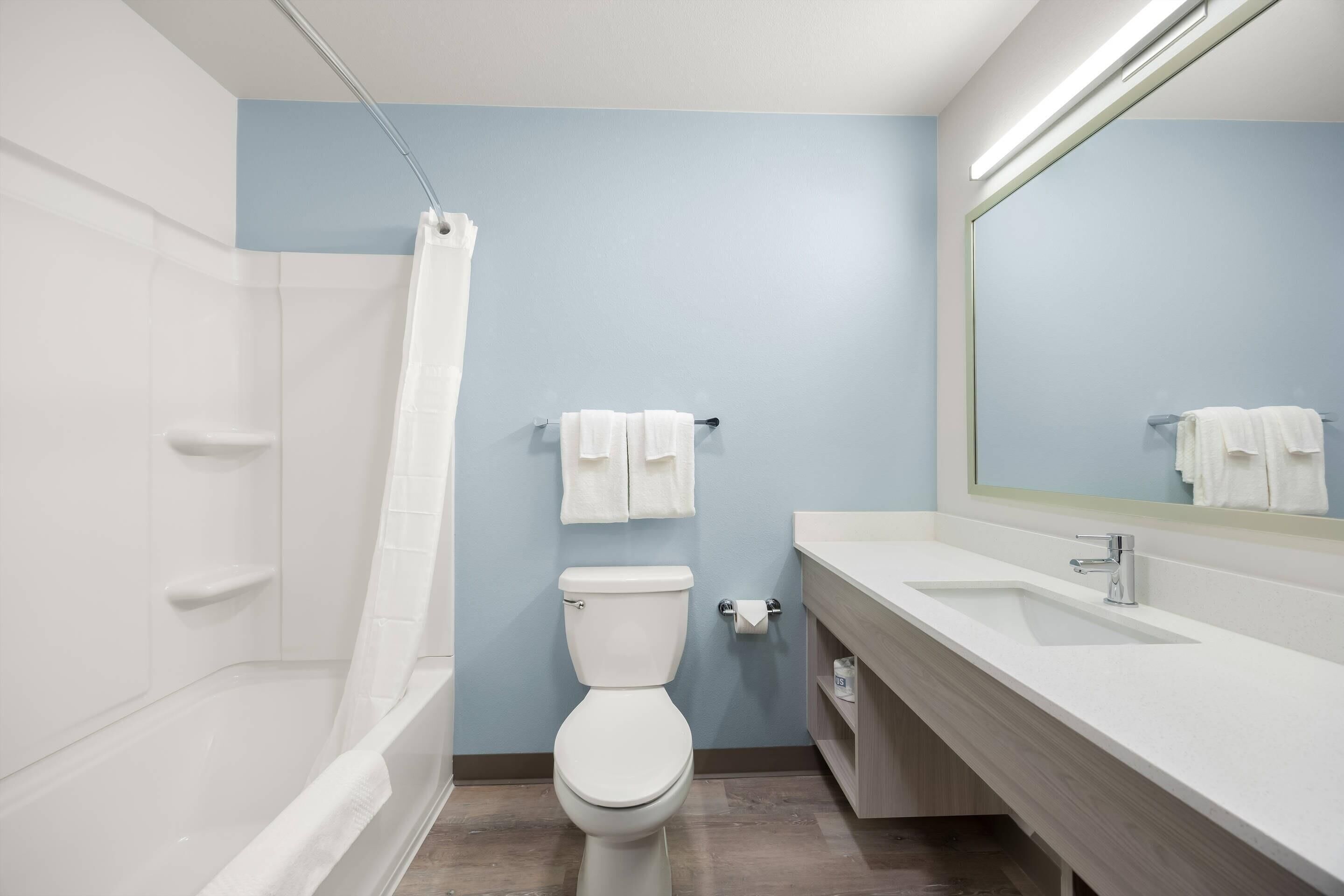Ein modernes Badezimmer mit Badewanne, Toilette und Waschbecken.