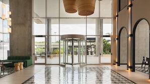 A lobby with a revolving door, a green sofa, and a patterned floor. - Faranda Collection Cartagena, a member of Radisson Individuals (Cartagena)