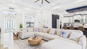 Una sala moderna con un sofá modular, una mesa de centro redonda y un ventilador de techo.