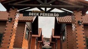 A brick building with a sign reading "DECK PEREIRAÃ". - POUSADA DECK PEREIRÃO (Santa Terezinha)