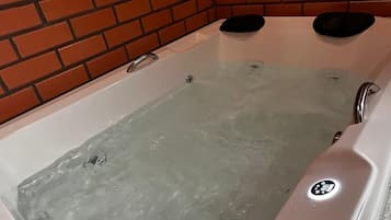 Quarto casal luxo | Banheiro | Banheira e chuveiro separados, toalhas de banho, sabonete, shampoo