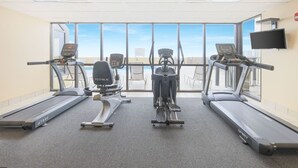 A gym with three treadmills, a stationary bike, and a rowing machine.